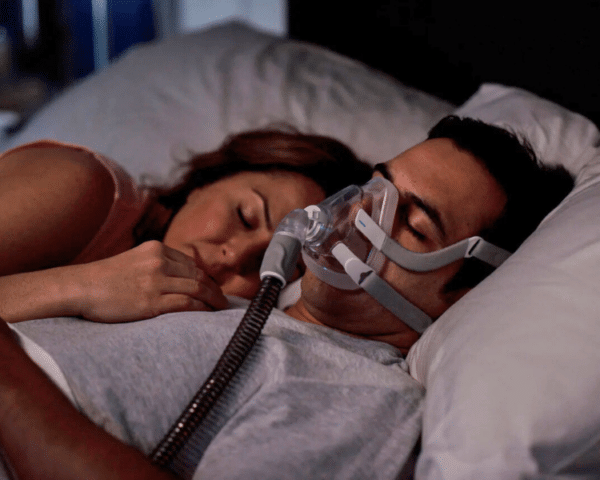 Hombre durmiendo con su pareja mientras lleva puesta la mascarilla facial airfit f20