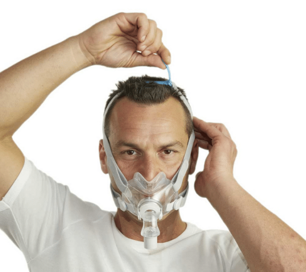 Hombre ajustandose la mascarilla Airfit f30 de resmed Hombre ajustandose la mascarilla Airfit f30 de resmed