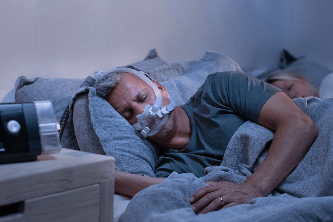 Hombre durmiendo con su pareja usando su equipo cpap